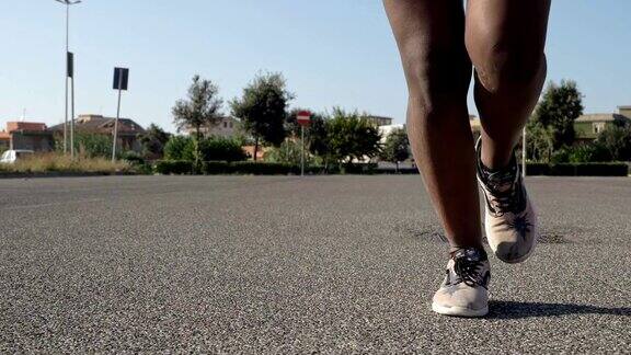 在街上奔跑的黑人女运动员肌肉发达的腿训练运动