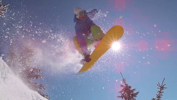 慢镜头特写:激动的滑雪运动员跳过太阳在山的边远