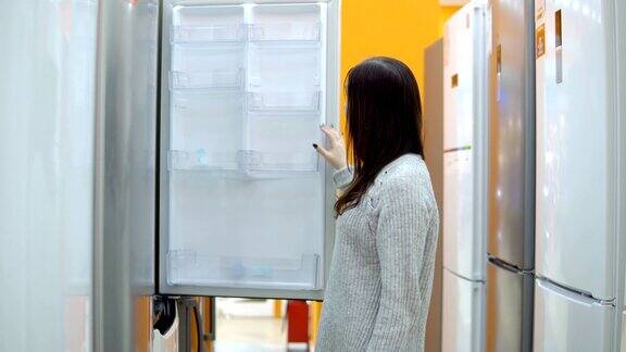 家用电器商店一位年轻女子选择了一台电冰箱