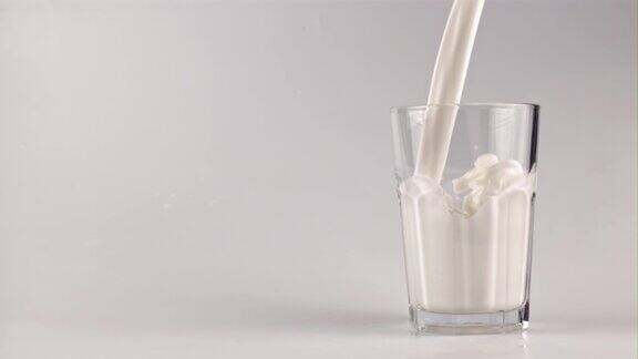 超级慢动作牛奶喷射到玻璃杯中用高速摄像机以每秒1000帧的速度拍摄