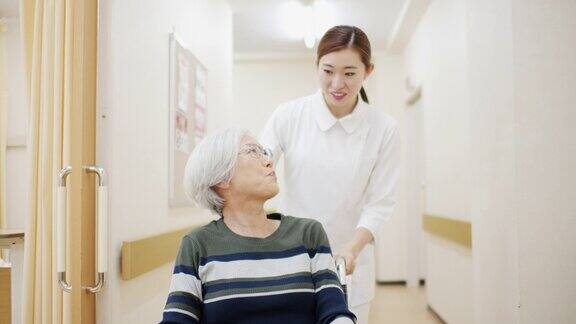 护士用轮椅推病人走过医院走廊