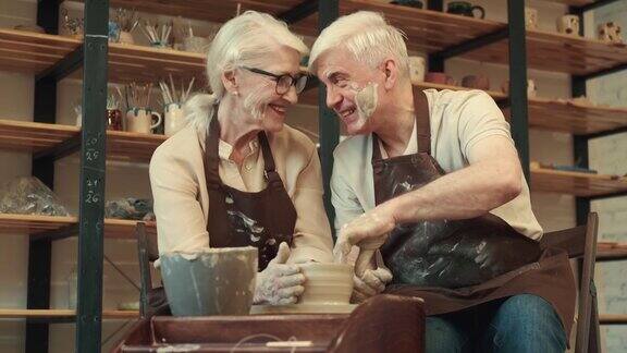 快乐的老年妇女和男子在陶器