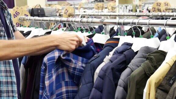 服装店货架上的一排各式各样的夹克男顾客挑选一件方格的
