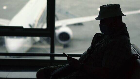 病毒一名戴着医用口罩的男子正在机场等飞机