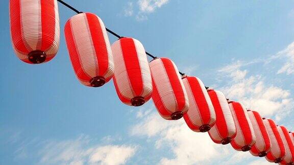 纸上红白相间的日本灯笼挂在蓝天的背景上