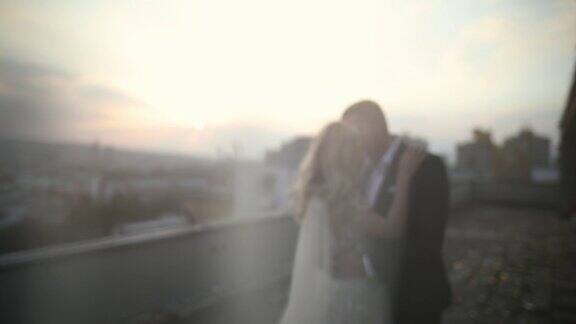 日落时分一对年轻夫妇在屋顶上跳舞