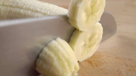 用菜刀在木制砧板上切香蕉