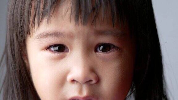 肖像脸的亚洲小女孩与悲伤的表情在黑暗的背景