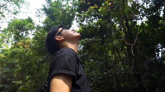 英俊的亚洲人站在森林里恢复精神感到不可思议给它拍张照片