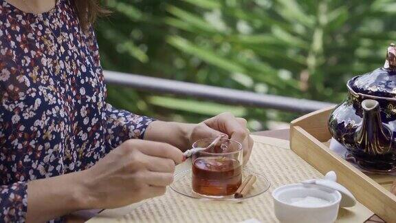 头部特写的西班牙裔年轻女子在户外阳台喝一杯热茶
