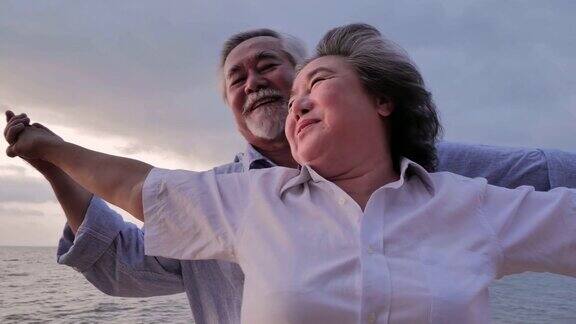一对老年夫妇在海上看日落在阳光明媚的日子里一对老年夫妇在海边放松