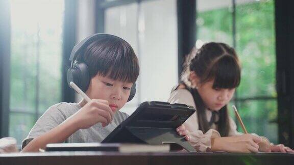 由于冠状病毒大流行亚洲小女孩通过数字远程互联网会议从学校老师那里学习在线课程孩子看着电脑笔记本电脑屏幕那个女人在教书