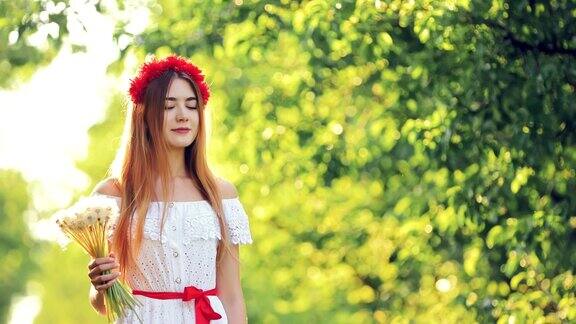 快乐的女孩带着鲜花在阳光明媚的日子里走过草地一名年轻女子手持一束白色的蒲公英