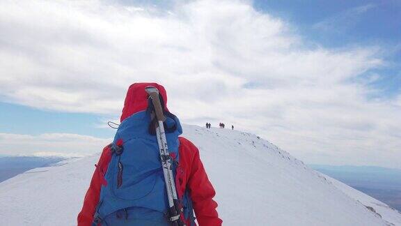 一名女性高山攀登者正在冬季与她的团队一起攀登高海拔的山峰