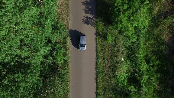 无人机观察汽车在高速公路上通过夏天的森林在农村