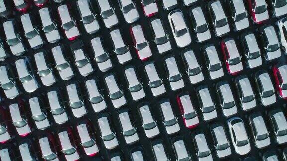 从空中俯瞰的新汽车停在停车场汽车经销商的停车场满是新车新车排队等待进出口业务