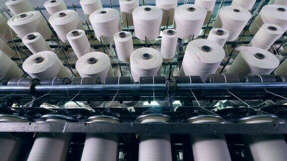 在工厂的机器上纺丝的许多线轴纺织厂设备在工作