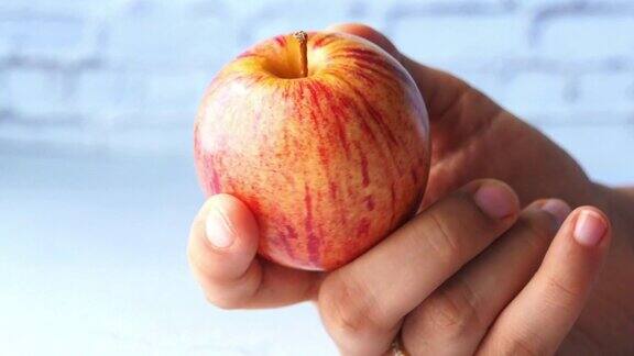 红熟的苹果在女人手上孤立在白色