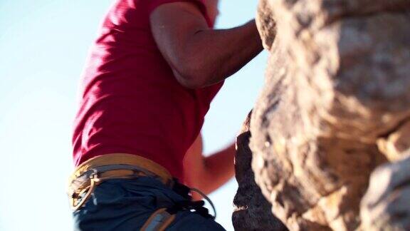 极端自由攀爬的人挂在岩石上的低角度