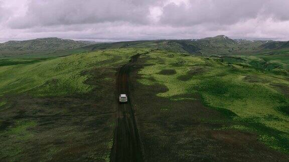 空中跟踪拍摄的银色4x4越野车行驶在山顶的山路