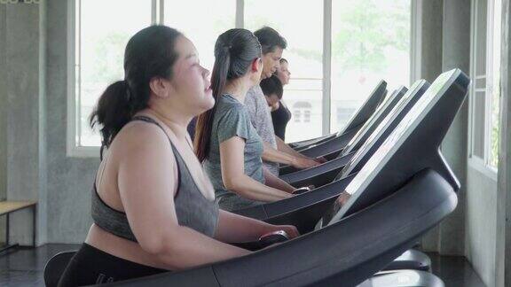 人们在健身房的跑步机上行走