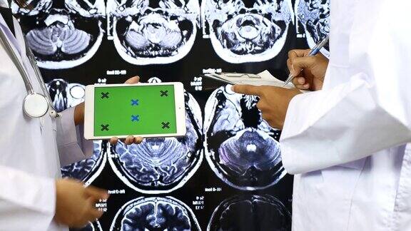 医生用电子平板电脑向另一个医生解释绿色屏幕绿色屏幕