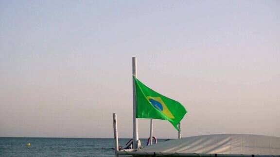日落时分海滩上飘扬着巴西国旗