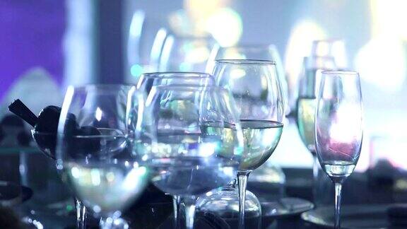 餐厅桌上的玻璃酒杯舞台灯光背景暗色浅景深特写