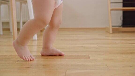 光脚婴儿在木地板上行走