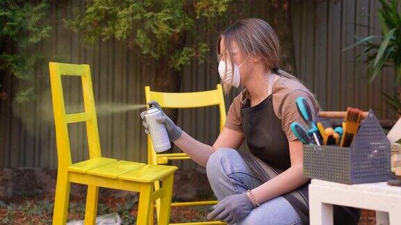 年轻妇女在后院粉刷家具