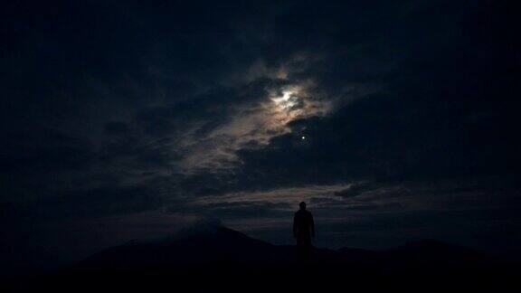 不明飞行物在月光背景下飞过一个男人