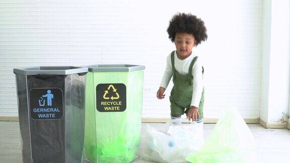 两个不同种族的孩子帮助把塑料瓶分成可回收的垃圾箱