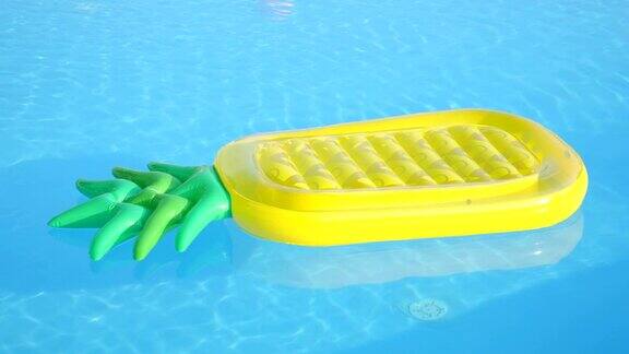 特写:空的充气菠萝漂浮在游泳池的水