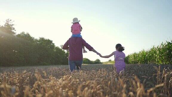 一位慈爱的父亲喜欢在日落时分和他漂亮的女儿们穿过麦田