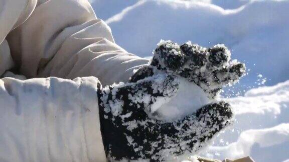 一个十几岁的男孩在冬天玩雪打雪仗把雪扔在手里明媚的冬日