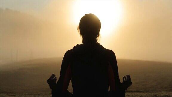 一个年轻女子在日出时练习瑜伽