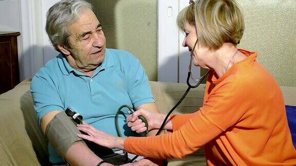 护士在家给一位七十岁的老人量血压