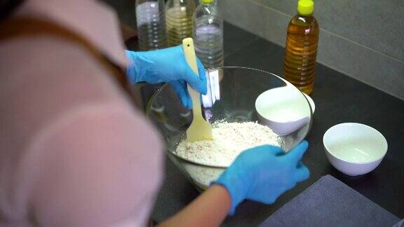 亚洲妇女戴着手套在厨房里做月饼面团