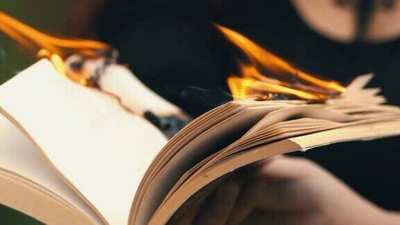 一个哥特式女人手里拿着一本燃烧的书