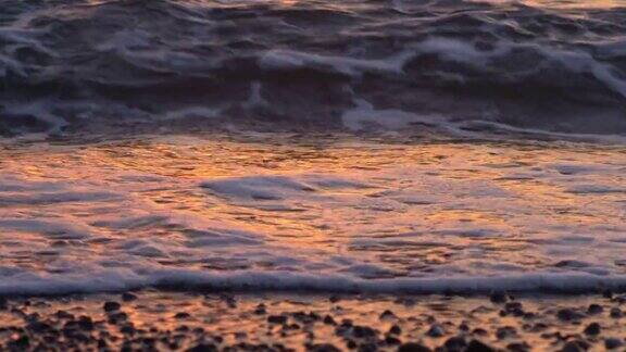 日出时海浪在海滩上拍打