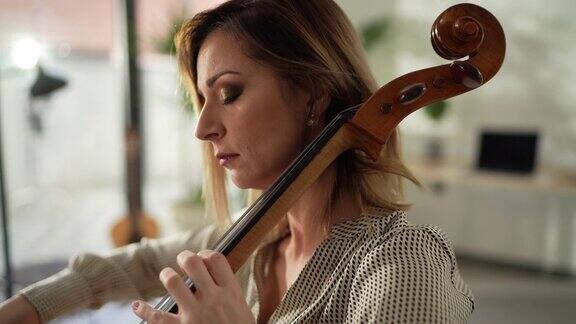 女人坐在工作室里演奏大提琴
