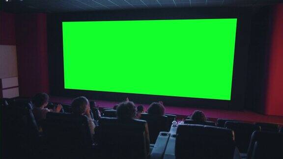 观众拍手看绿色色度键电影屏幕的慢动作