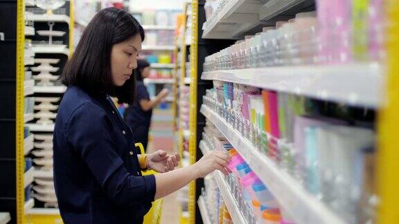 女人在超市选购塑料制品慢动作