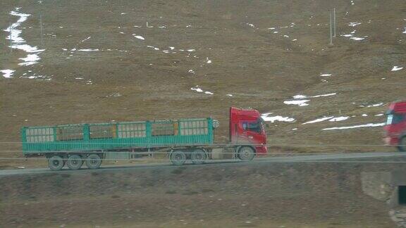 一辆带空拖车的红色老卡车沿着风景优美的道路行驶