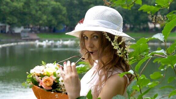 一个漂亮的白人女孩戴着白色的帽子手里拿着一束鲜花