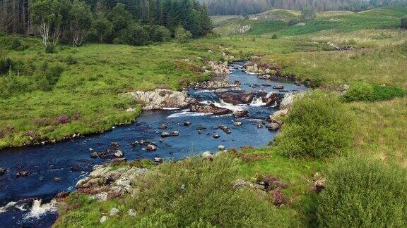 一架无人机从苏格兰乡村地区的一条苏格兰河的高角度视角