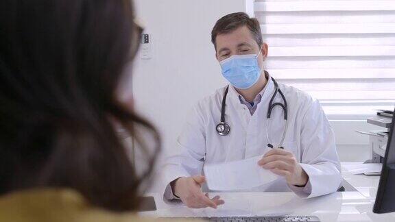 医生微笑着保护面罩给女病人开处方