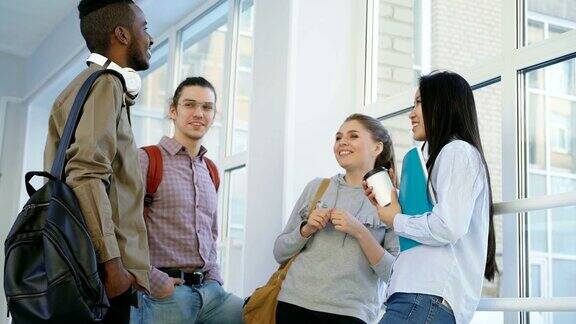 多民族的学生们正站在大学靠窗的宽阔走廊上积极地交流着微笑着大笑着非洲裔学生要离开了