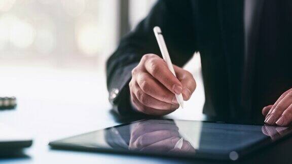 商人用手写笔在平板电脑上签署数字合同