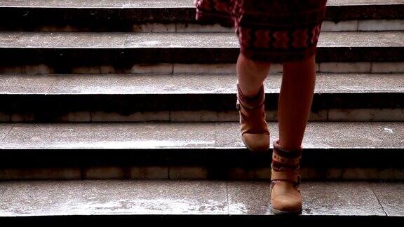 特写女人的脚走下大理石楼梯